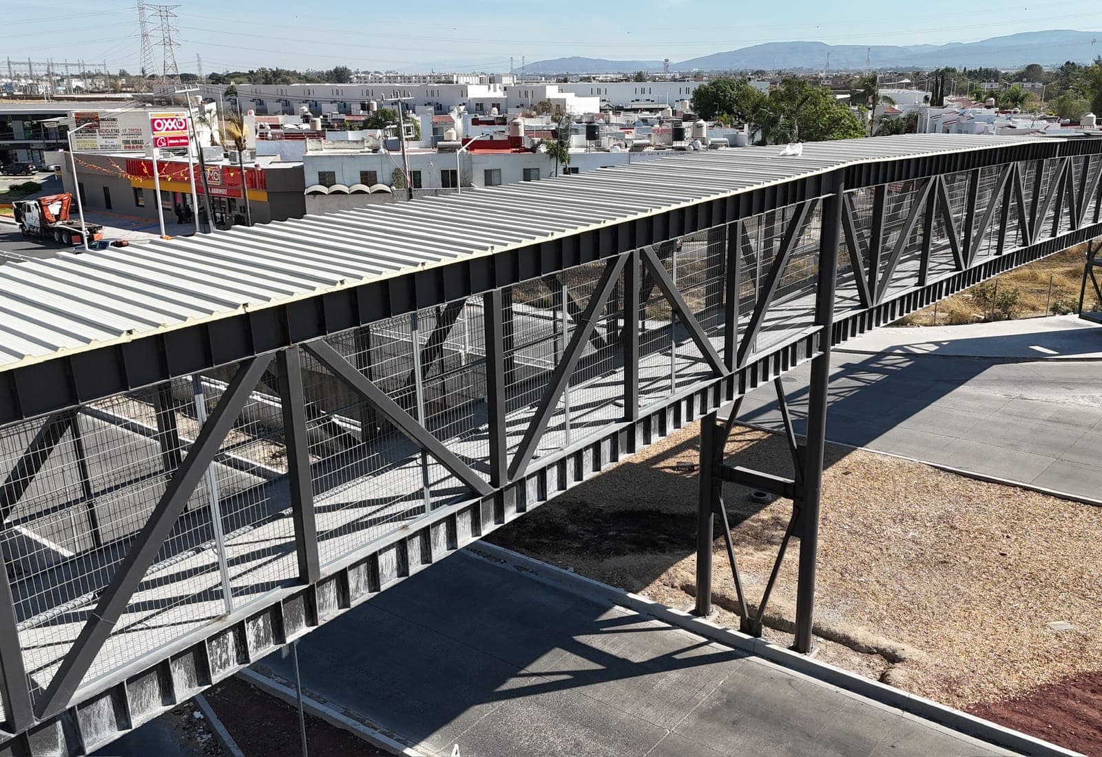 Puente peatonal del Nodo Colotlán con su cubierta laminada, visto a lo largo de la estructura de acero